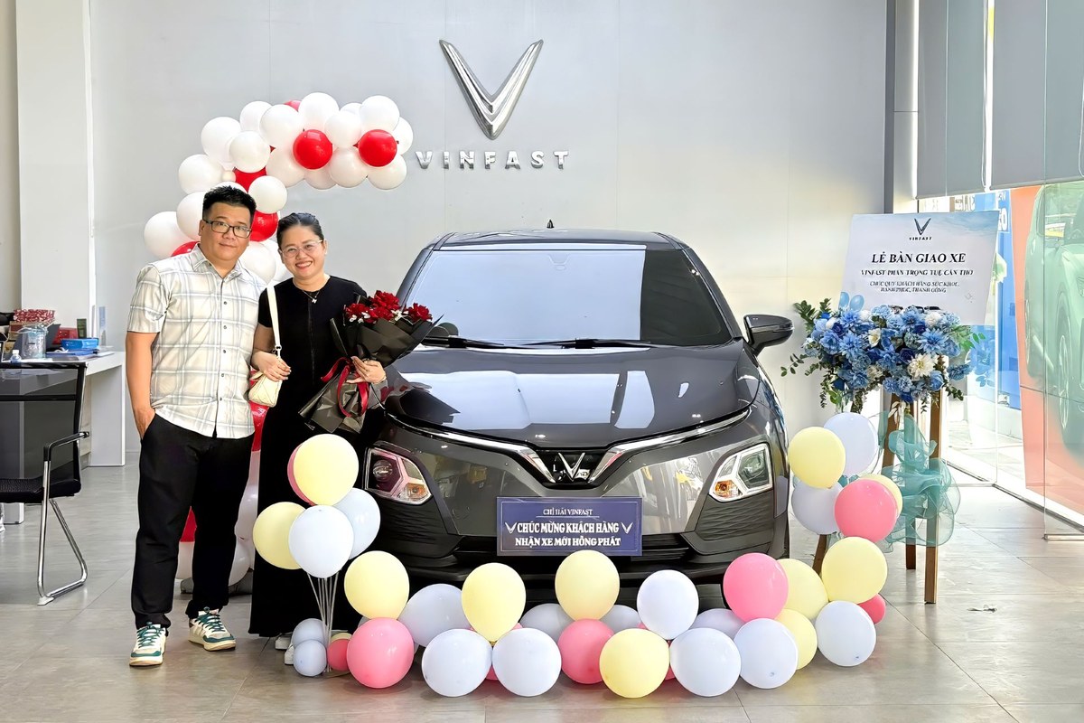 Cặp đôi tươi cười nhận bàn giao VinFast VF 5 màu xám đậm tại showroom Cần Thơ.