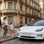 Gia đình Tây Ban Nha đi bộ tới chiếc xe điện Tesla Model 3 đỗ trước tòa nhà góc vát tại Barcelona
