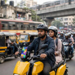 Tài xế xe ôm công nghệ chạy xe máy điện màu vàng trên đường phố Mumbai, Ấn Độ