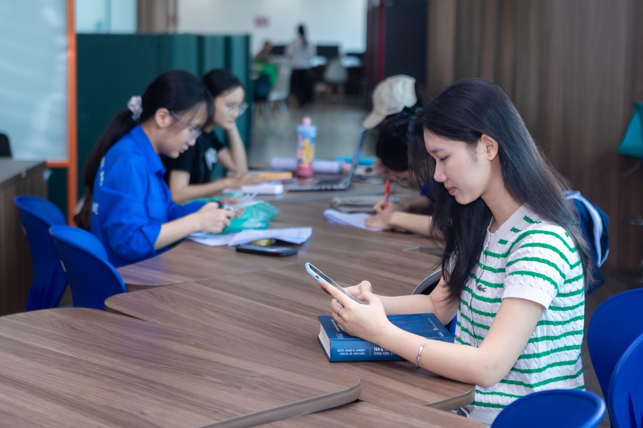 Bạn trẻ sử dụng điện thoại trong không gian học tập và làm việc nhóm