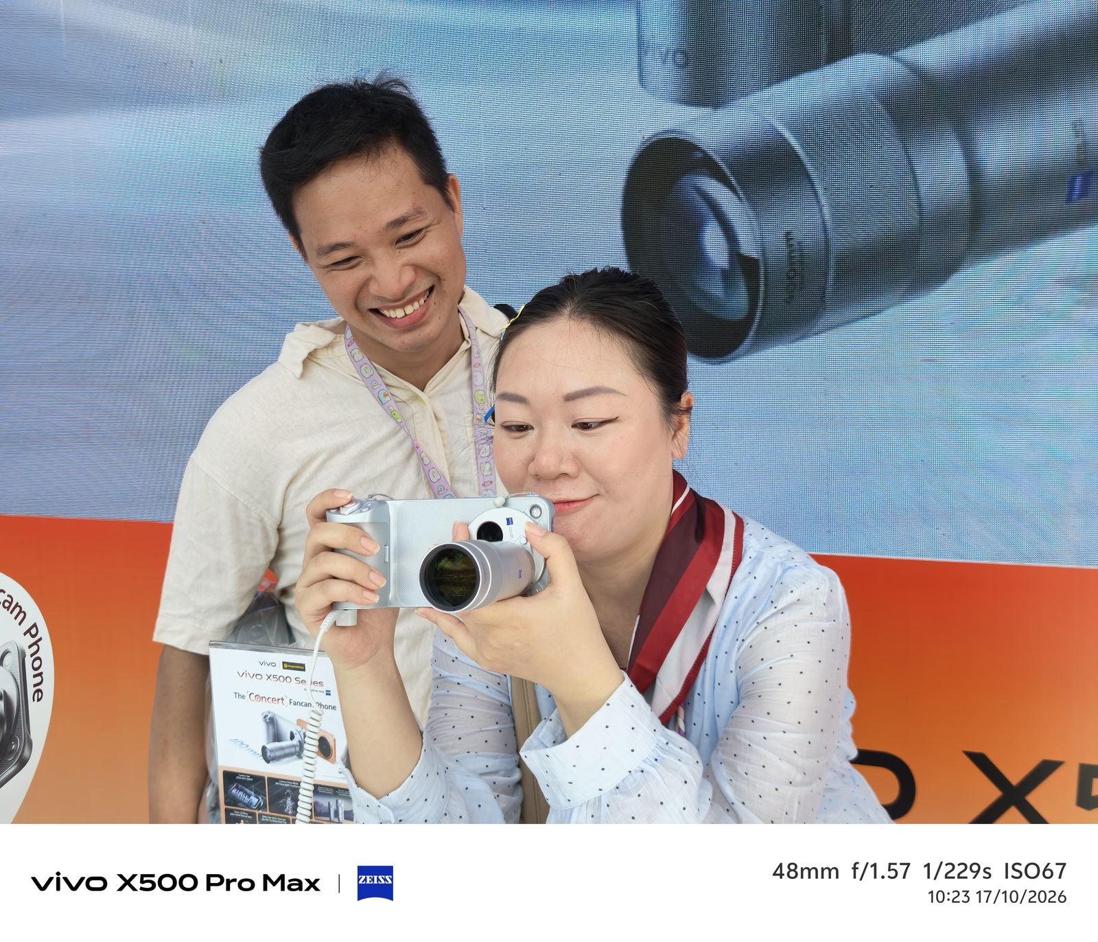 Khách tham dự trải nghiệm vivo X500 Pro Max với tay cầm chụp ảnh tại gian hàng